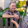 Picture of neighbours talking to each other over the fence.